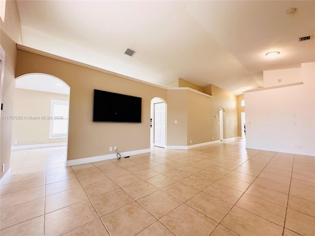 unfurnished room with lofted ceiling and light tile patterned floors