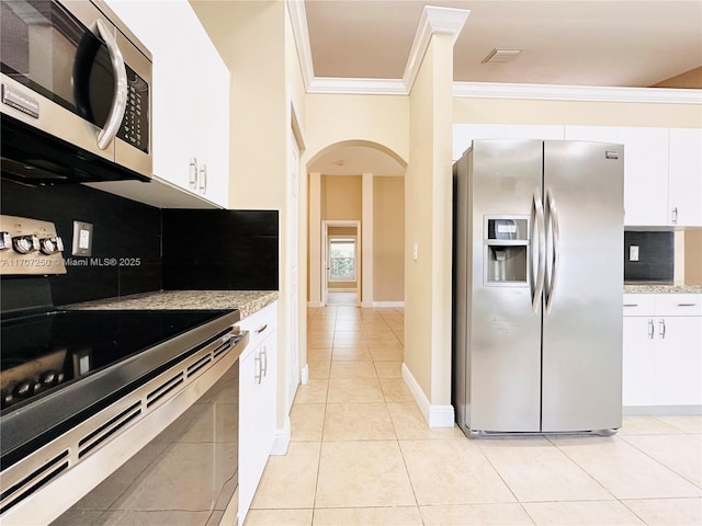 kitchen with light tile patterned flooring, white cabinetry, appliances with stainless steel finishes, and tasteful backsplash