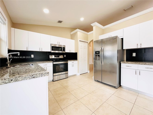 kitchen with decorative backsplash, sink, white cabinets, and appliances with stainless steel finishes