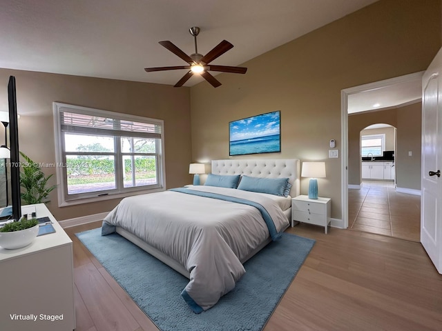 bedroom featuring ceiling fan, lofted ceiling, and light wood-type flooring