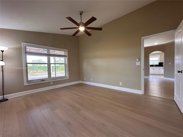 spare room featuring ceiling fan, lofted ceiling, and light hardwood / wood-style floors