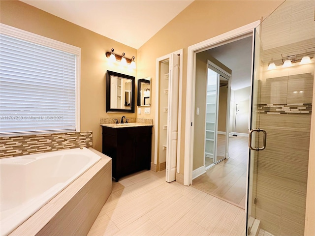 bathroom featuring lofted ceiling, vanity, and independent shower and bath