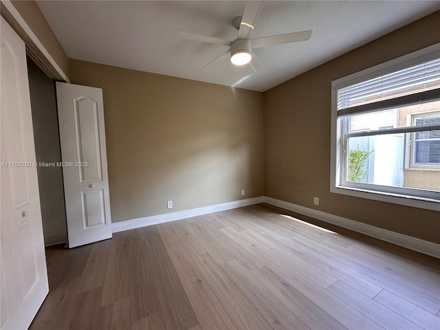 empty room with ceiling fan and light hardwood / wood-style flooring