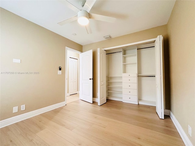 unfurnished bedroom with light wood-type flooring, ceiling fan, and a closet