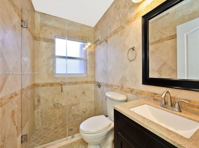 bathroom with tile walls, walk in shower, vanity, and toilet