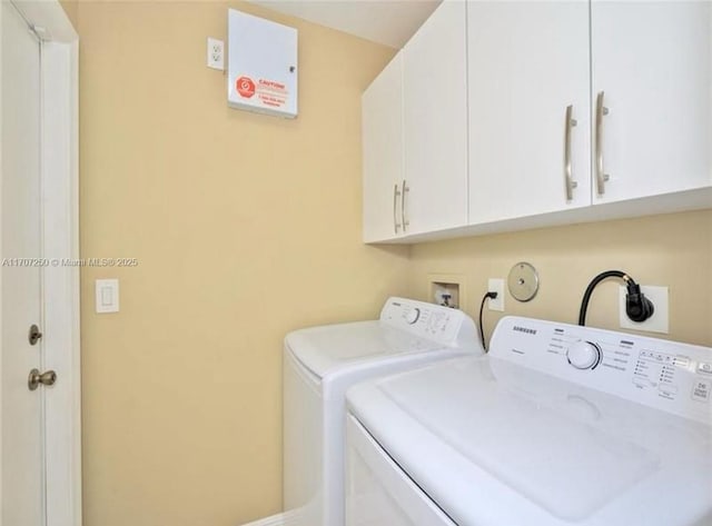 washroom featuring separate washer and dryer and cabinets