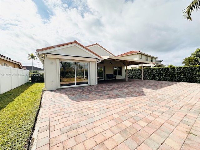 rear view of property featuring a patio area and a lawn