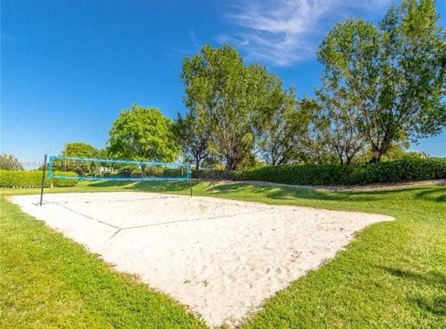 view of community with a lawn and volleyball court