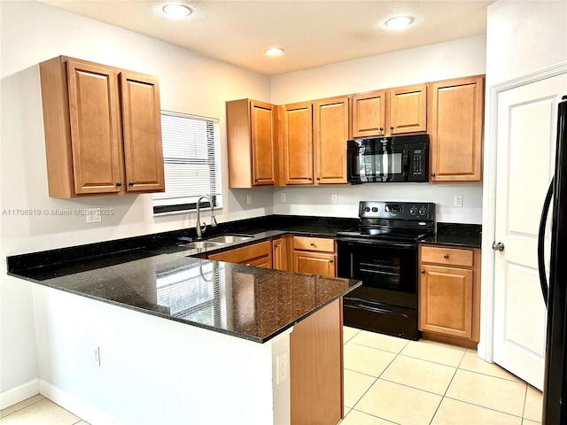 kitchen featuring light tile patterned flooring, sink, dark stone countertops, kitchen peninsula, and black appliances