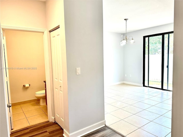 tiled empty room with a chandelier