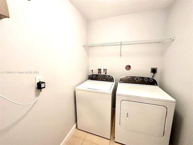 laundry room with washer and dryer and light tile patterned flooring