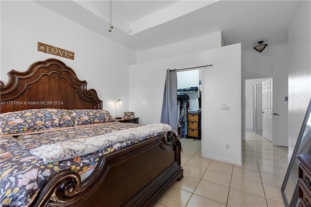 bedroom with a walk in closet and light tile patterned floors