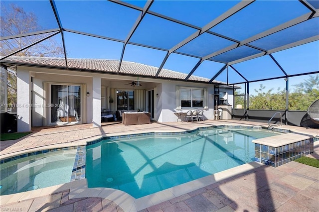 view of swimming pool with a patio, glass enclosure, and ceiling fan