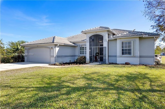 mediterranean / spanish home with a garage and a front lawn