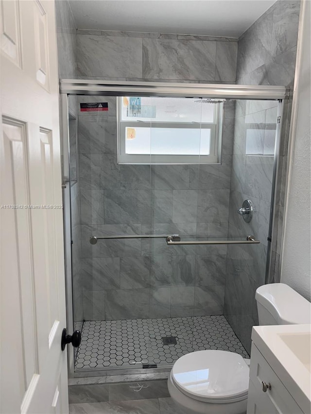 bathroom featuring vanity, an enclosed shower, and toilet