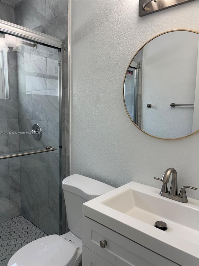 bathroom featuring vanity, toilet, and a shower with door