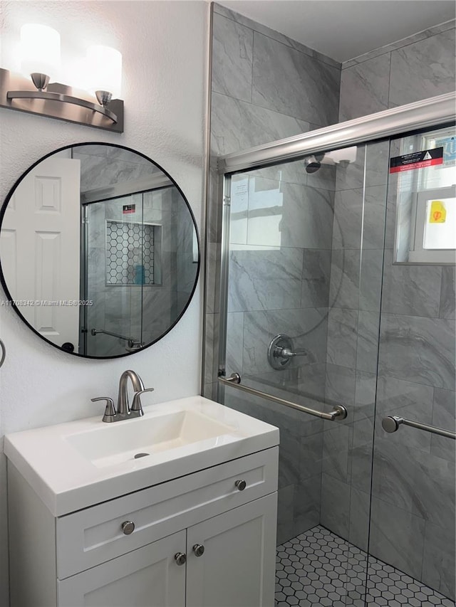 bathroom with vanity and a shower with door