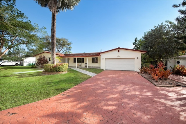 mediterranean / spanish-style home featuring a garage and a front lawn