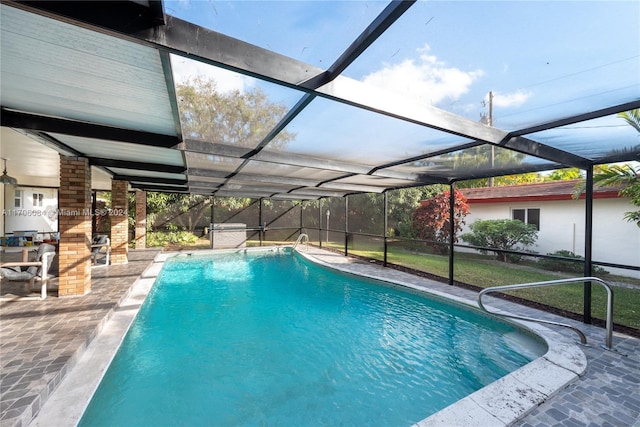 view of pool with glass enclosure and a patio area