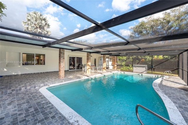 view of swimming pool with glass enclosure and a patio area