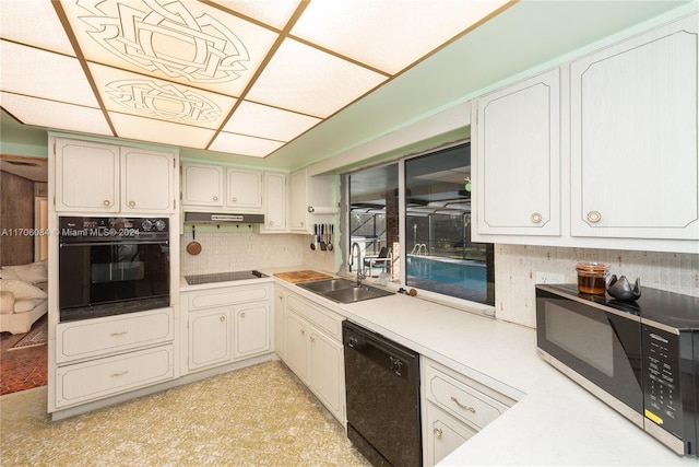 kitchen featuring black appliances, backsplash, white cabinetry, and sink