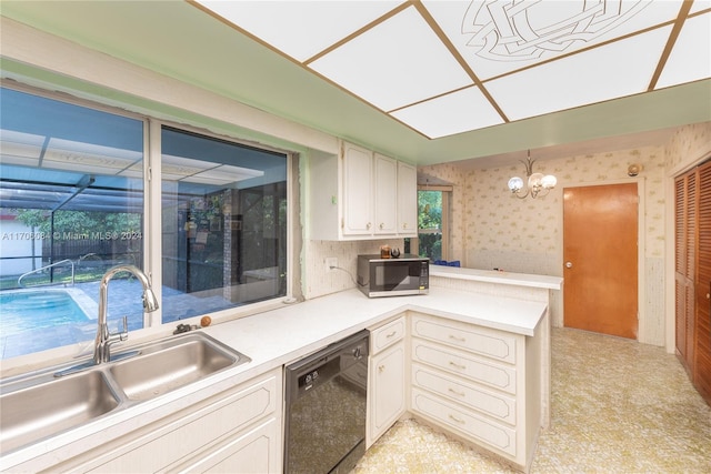 kitchen with pendant lighting, white cabinets, sink, black dishwasher, and a chandelier