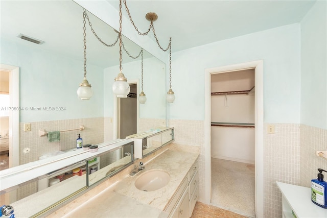 bathroom with vanity and tile walls