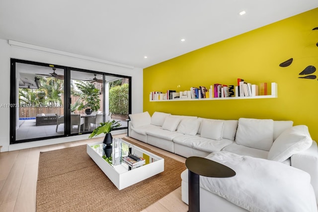 living room with light hardwood / wood-style floors and ceiling fan