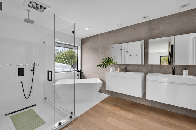 bathroom with wood-type flooring, vanity, and separate shower and tub