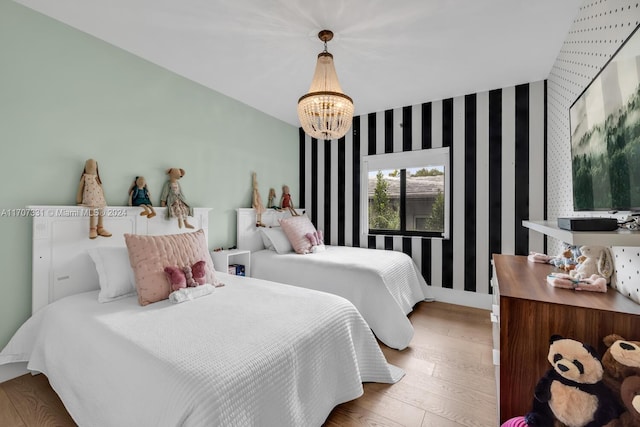 bedroom with light wood-type flooring and an inviting chandelier