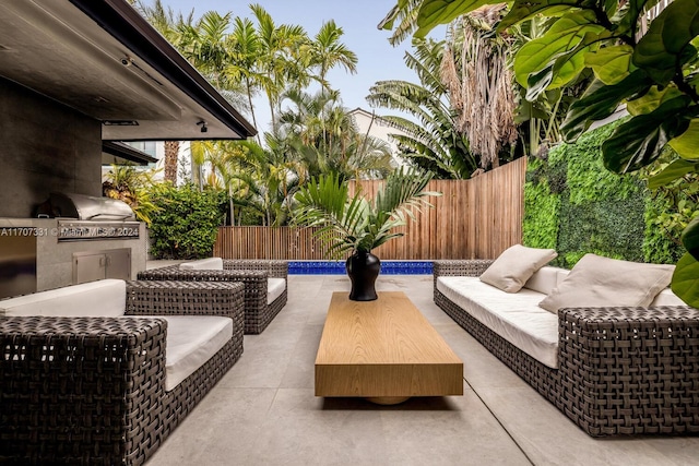 view of patio featuring a fenced in pool, area for grilling, outdoor lounge area, and an outdoor kitchen