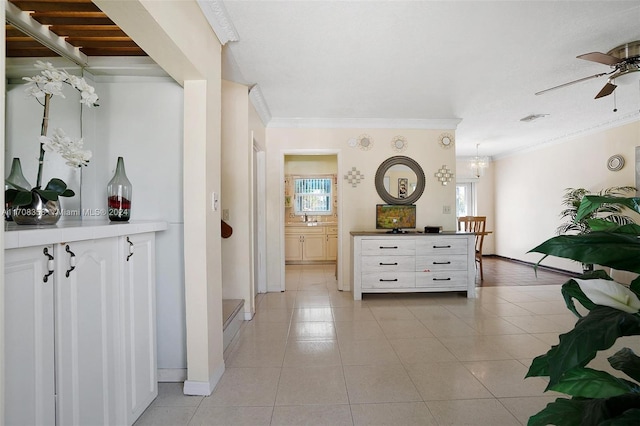 interior space featuring light tile patterned floors, ornamental molding, and sink