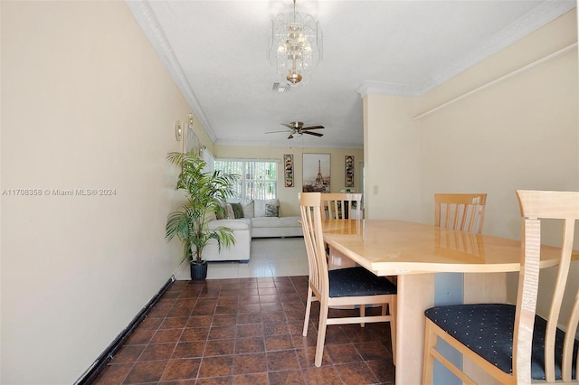 unfurnished dining area featuring ceiling fan with notable chandelier, dark tile patterned floors, and ornamental molding