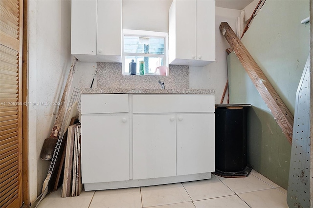 kitchen with white cabinetry, sink, light tile patterned floors, and tasteful backsplash