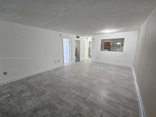 unfurnished room featuring a textured ceiling