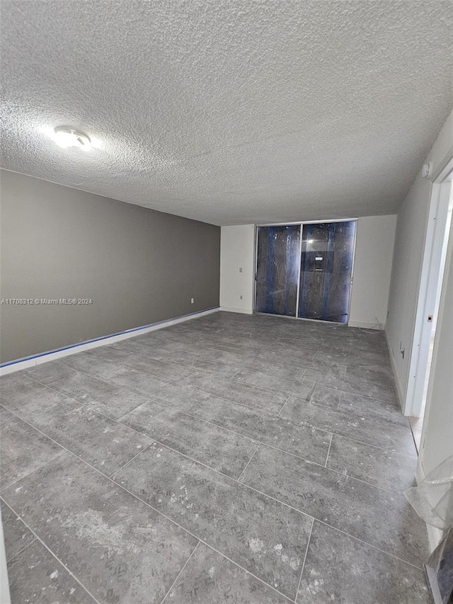 unfurnished room with a textured ceiling