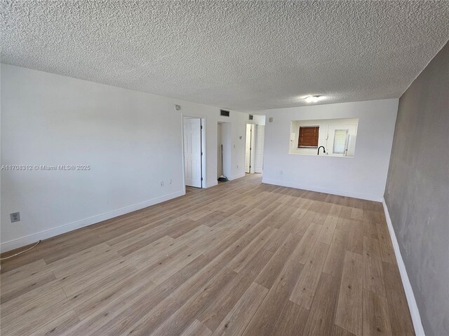 3600 NE 170th St Unit 402, North Miami Beach, FL 33160 - unfurnished room with light wood-style flooring and a textured ceiling