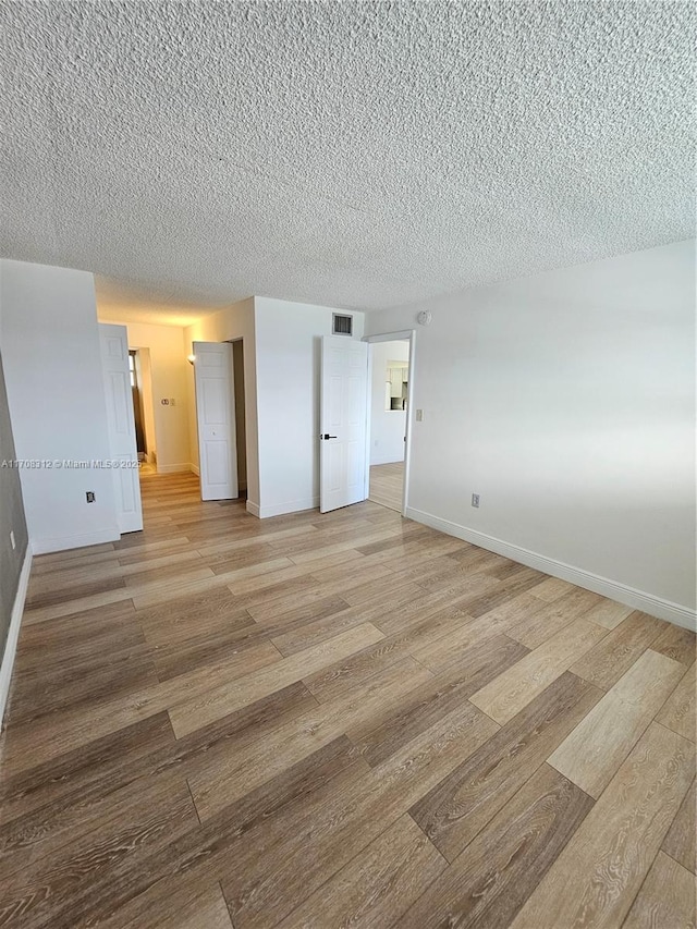 3600 NE 170th St Unit 402, North Miami Beach, FL 33160 - unfurnished bedroom featuring light wood-type flooring and a textured ceiling