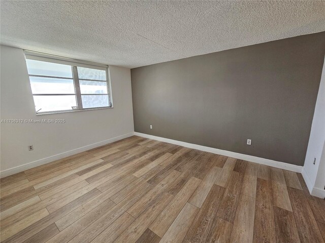 3600 NE 170th St Unit 402, North Miami Beach, FL 33160 - unfurnished room with a textured ceiling and light wood finished floors