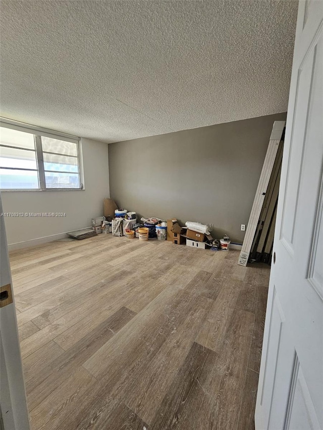 empty room featuring light wood-type flooring and a textured ceiling