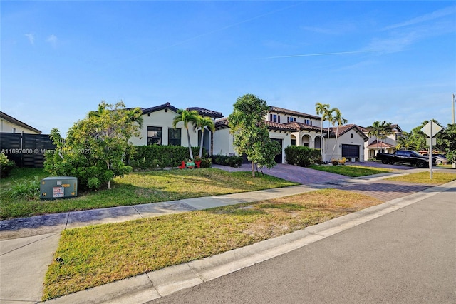view of front of property with a garage, stucco siding, decorative driveway, and a front yard
