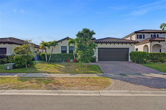 view of front of home featuring a garage, stucco siding, a tile roof, and decorative driveway