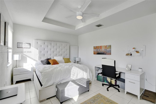 bedroom featuring light tile patterned floors, visible vents, a raised ceiling, and ceiling fan