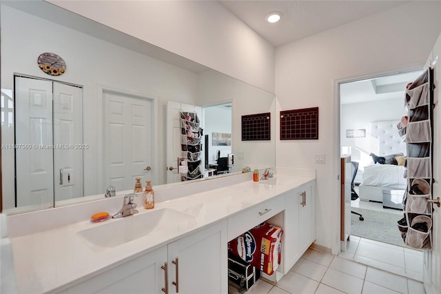 bathroom with tile patterned flooring, a closet, double vanity, ensuite bathroom, and a sink