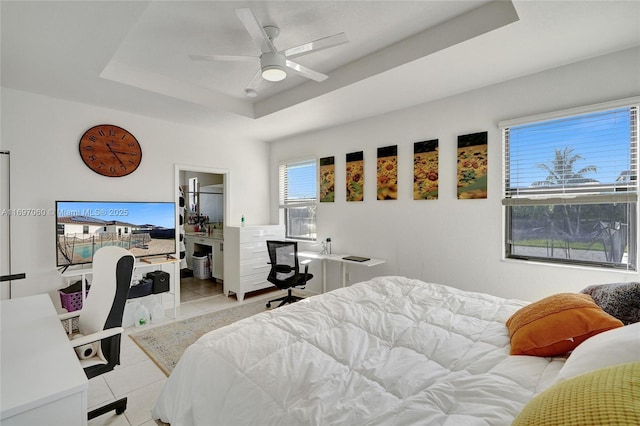 bedroom with a raised ceiling, a ceiling fan, and light tile patterned flooring