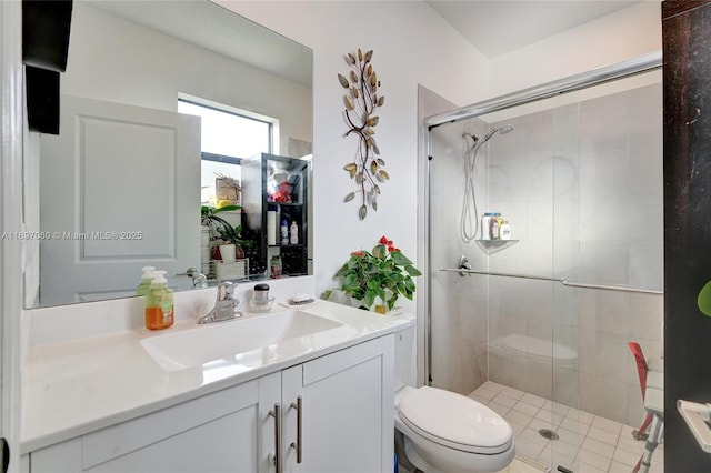 full bathroom featuring a stall shower, toilet, and vanity