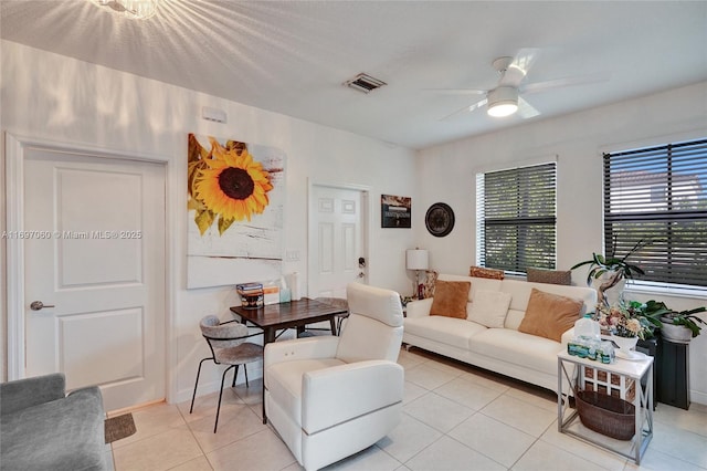 living room featuring light tile patterned floors, visible vents, and ceiling fan