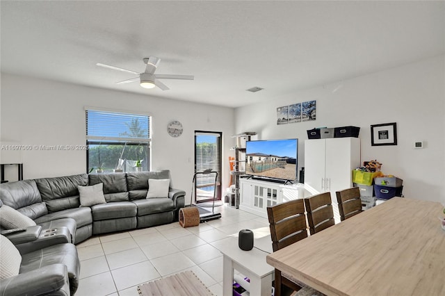 living room featuring light tile patterned floors, visible vents, and ceiling fan