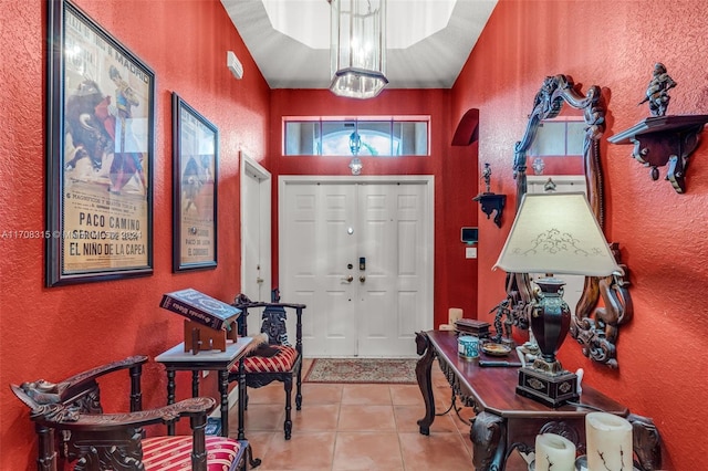 entrance foyer featuring light tile patterned floors, vaulted ceiling, and a notable chandelier