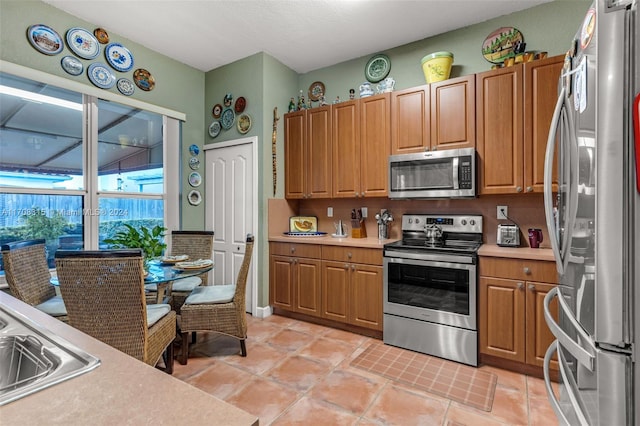 kitchen with light tile patterned floors, sink, and appliances with stainless steel finishes